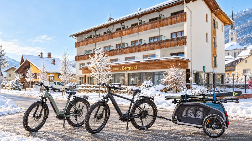 KI-Konzeptbild von zwei Winterfahrrädern und einem angepassten Ski-Anhänger vor dem Hotel Bergland; die Zusammenarbeit mit Papin ist noch offen.